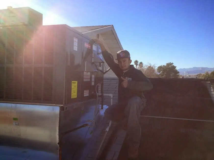 HVAC technician performing HVAC Inspection on a rooftop unit in Canby